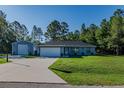 Beautiful home with well-maintained lawn, a long driveway, and an additional building at 9085 Sw 202Nd Avenue Rd, Dunnellon, FL 34431