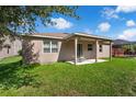 The backyard boasts a covered patio, a lush lawn, and an exterior view of the home at 2960 Boating Blvd, Kissimmee, FL 34746