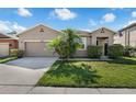 Inviting single-story home featuring a well-maintained lawn, beautiful palm tree, and attached garage at 2960 Boating Blvd, Kissimmee, FL 34746
