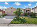 Well-maintained home featuring a manicured lawn, lush landscaping, and an attached two-car garage at 2960 Boating Blvd, Kissimmee, FL 34746