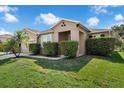 This home features a manicured lawn, trimmed hedges, an entry portico, and an attached two-car garage at 2960 Boating Blvd, Kissimmee, FL 34746