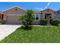 Charming single-story home with a well-manicured lawn, showcasing curb appeal and a neutral color palette at 2960 Boating Blvd, Kissimmee, FL 34746