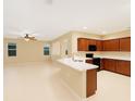 Open concept kitchen featuring dark wood cabinetry, a breakfast bar, and modern appliances at 2960 Boating Blvd, Kissimmee, FL 34746