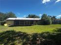 Expansive backyard featuring lush grass and a screen enclosed patio, perfect for outdoor enjoyment at 15 Monroe Ave, Debary, FL 32713