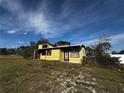 View of a single story house with large overgrown lot and trees on a sunny day at 1925 Laredo Dr, Deltona, FL 32738