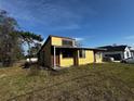 Side view of a two-story yellow home, adjacent to a well kept neighboring home at 1925 Laredo Dr, Deltona, FL 32738