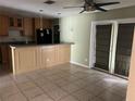 Kitchen area with light wood cabinets, breakfast bar, tile floor, and sliding doors to the back at 116 Wild Holly Ln, Longwood, FL 32779