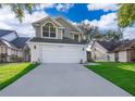 Traditional two-story home featuring a two-car garage, complemented by lush green lawn at 1839 Cranberry Isles Way, Apopka, FL 32712