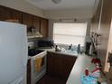Kitchen features wood cabinets, white appliances and a large window for natural light at 3509 Lisa Ln, Lakeland, FL 33801