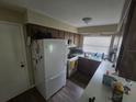 Kitchen features wood cabinets, white appliances, laminate flooring and a window for natural light at 3509 Lisa Ln, Lakeland, FL 33801