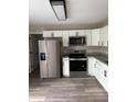 Well-lit kitchen featuring stainless steel appliances, granite countertops and modern white cabinetry at 5356 Spivey Glen Ct, Lakeland, FL 33810