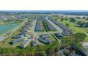 Expansive aerial view of a neatly planned community showcasing rows of houses, golf course, and a tranquil lake at 6185 Sw 89Th Ct, Ocala, FL 34481
