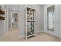 Welcoming entryway featuring a decorative glass door, a display cabinet, and light tile flooring at 6185 Sw 89Th Ct, Ocala, FL 34481