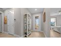 Bright entryway with glass door, stylish display cabinet, and a glimpse into a bedroom with natural light at 6185 Sw 89Th Ct, Ocala, FL 34481