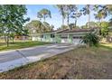 Low angle shot of the exterior of a house featuring a large driveway and a two car garage at 641 Jackson St, Eustis, FL 32726