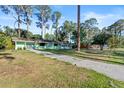 Wide angle exterior featuring a single story home with an overgrown lawn and a concrete driveway at 641 Jackson St, Eustis, FL 32726