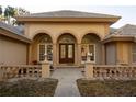 Stunning front entrance with elegant arched windows, a solid wood door, and manicured landscaping at 1695 Horseshoe Rd, Deltona, FL 32725