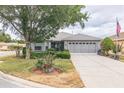 Charming home features a well-manicured lawn, mature trees, and an attached two-car garage at 9107 Sw 102Nd Cir, Ocala, FL 34481
