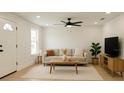 Bright living room with neutral decor, ceiling fan, a large window, and vinyl floors at 991 Polk St, Bartow, FL 33830