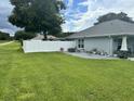 A spacious backyard, with a stone patio, complemented by vibrant potted plants at 10470 Sw 132Nd Ct, Dunnellon, FL 34432