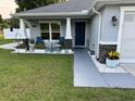 Inviting porch, with seating, enhanced by decorative plants and stylish accents at 10470 Sw 132Nd Ct, Dunnellon, FL 34432