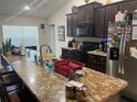 Well-equipped kitchen features dark wood cabinets and an extended granite countertop with a breakfast bar at 31517 Broadwater Ave, Leesburg, FL 34748