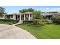 Charming home featuring a landscaped front yard, covered porch and a circular driveway at 1410 Poinsettia Ave, Orlando, FL 32804