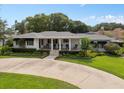 Charming home featuring a landscaped front yard, covered porch and a circular driveway at 1410 Poinsettia Ave, Orlando, FL 32804