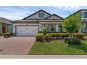 Inviting home with a brick driveway and verdant landscaping providing attractive curb appeal at 1896 Napoli Dr, St Cloud, FL 34771