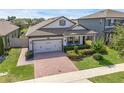 Charming home showcasing a brick driveway, manicured lawn, and lovely landscaping at 1896 Napoli Dr, St Cloud, FL 34771