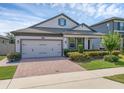Attractive home features a brick driveway, two-car garage, and manicured front lawn at 1896 Napoli Dr, St Cloud, FL 34771