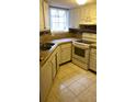 Cozy kitchen with tiled countertops and flooring and white appliances at 1948 Lake Atriums Cir # 132, Orlando, FL 32839