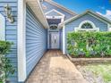 Entrance with blue siding, brick walkway and covered entryway at 2641 Delcrest Dr, Orlando, FL 32817