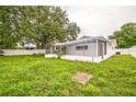 Spacious backyard featuring a screened lanai, partial fencing, and lush greenery, perfect for outdoor living at 7331 Blue Jacket W Pl, Winter Park, FL 32792