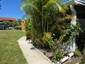 Exterior view showcasing the property's landscaping, including palm trees and colorful flowering plants at 4213 E Michigan St # 4213, Orlando, FL 32812