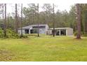 View of home showcasing the attached carport with driveway and lawn at 10411 County Road 474, Clermont, FL 34714