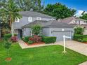 Gray two-story home with well-manicured lawn, lush landscaping, and an attached two-car garage at 9525 Southern Garden Cir, Altamonte Springs, FL 32714