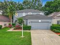 Charming gray two-story home featuring a well-manicured lawn and a spacious two-car garage at 9525 Southern Garden Cir, Altamonte Springs, FL 32714