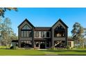 Modern two-story home with symmetrical design, large windows, and landscaped front yard at 2716 Delphi Hills Way, Lakeland, FL 33812