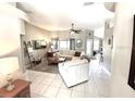 Spacious living room with tile flooring, a ceiling fan, and a cozy seating area for relaxation at 11315 Cypress Shore Ct, Clermont, FL 34711