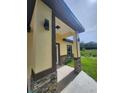 Inviting front porch with stone accents, modern lighting, and covered entry at 13074 Sw 104Th Ln, Dunnellon, FL 34432