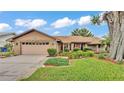 Inviting single-story home with an attached garage and manicured lawn at 4120 Chelsea Ln, Lakeland, FL 33809