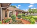 Charming single Gathering home with a well-manicured lawn, beautiful landscaping, and a red front door at 4120 Chelsea Ln, Lakeland, FL 33809