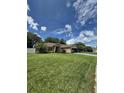 Charming single-story home with well-manicured lawn, landscaping, and blue driveway at 15917 Mercott Ct, Clermont, FL 34714