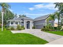 Beautiful home with a well-manicured lawn, brick driveway, and an attached two-car garage at 4013 Greystone Dr, Clermont, FL 34711