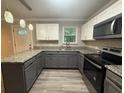 Updated kitchen with stainless steel appliances, gray cabinetry, and granite countertops at 5641 Nw 55Th Ave, Ocala, FL 34482
