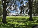 Exterior view showcases homes with lush green lawns and mature trees creating a serene neighborhood setting at 888 W Stuart St, Bartow, FL 33830