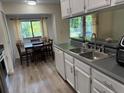 Well-lit kitchen with white cabinets, stainless steel appliances, a double sink, and a cozy breakfast nook with a view at 5523 Westview Dr, Orlando, FL 32810