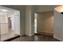 Bright and airy living room featuring new gray laminate flooring, neutral walls, and natural light streaming in through the door at 5523 Westview Dr, Orlando, FL 32810