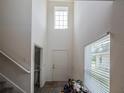Bright foyer with soaring ceilings, a large window, staircase, and a convenient half-bathroom to the left at 938 Mansfield Rd, Tavares, FL 32778